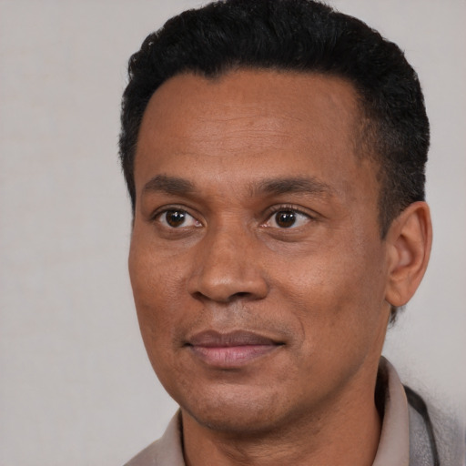 Joyful black adult male with short  black hair and brown eyes