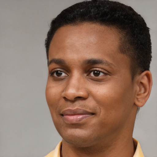 Joyful black young-adult male with short  brown hair and brown eyes
