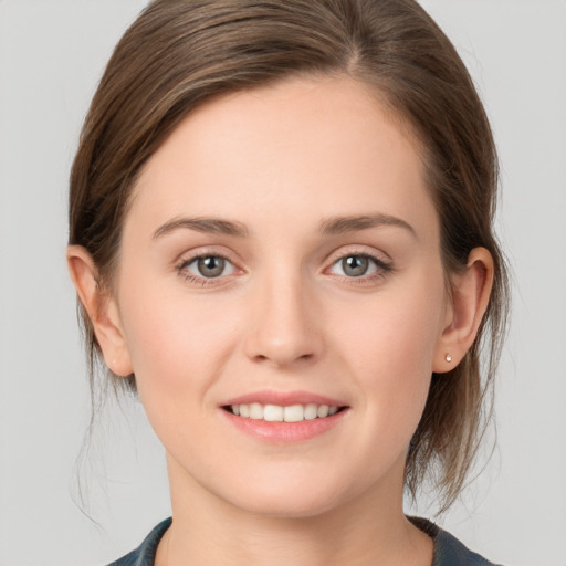 Joyful white young-adult female with medium  brown hair and grey eyes