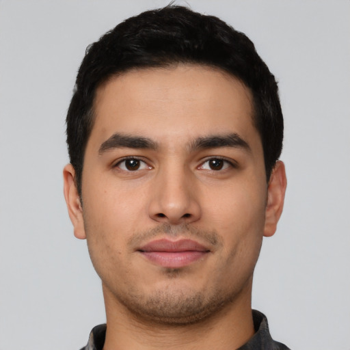 Joyful latino young-adult male with short  black hair and brown eyes