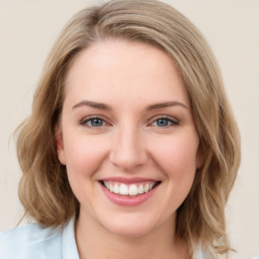 Joyful white young-adult female with medium  brown hair and blue eyes