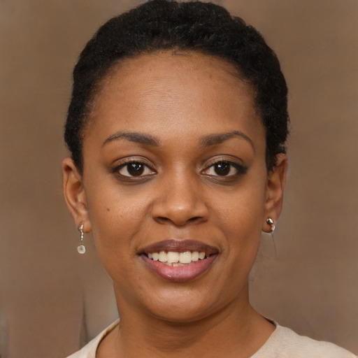 Joyful black young-adult female with short  brown hair and brown eyes