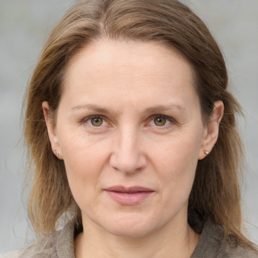 Joyful white adult female with medium  brown hair and grey eyes