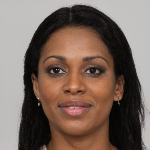 Joyful black young-adult female with long  black hair and brown eyes