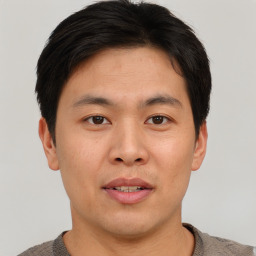 Joyful asian young-adult male with short  brown hair and brown eyes