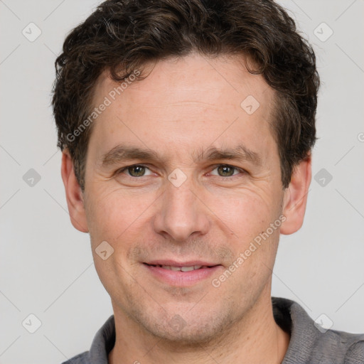 Joyful white adult male with short  brown hair and grey eyes