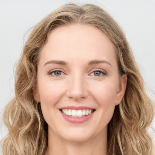 Joyful white young-adult female with long  brown hair and blue eyes