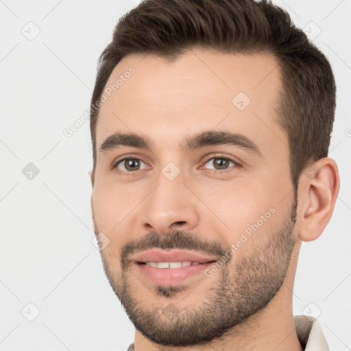 Joyful white young-adult male with short  brown hair and brown eyes