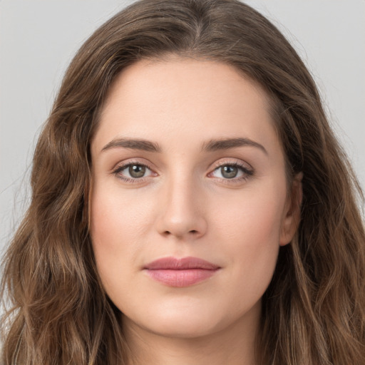 Joyful white young-adult female with long  brown hair and green eyes