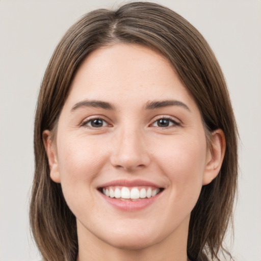 Joyful white young-adult female with medium  brown hair and grey eyes