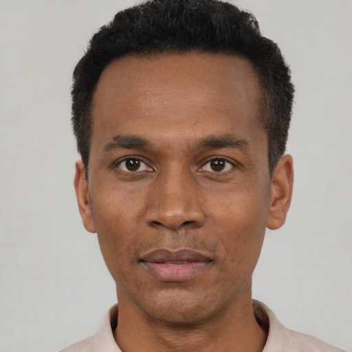 Joyful black adult male with short  black hair and brown eyes