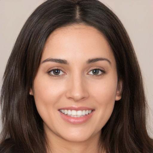 Joyful white young-adult female with long  brown hair and brown eyes