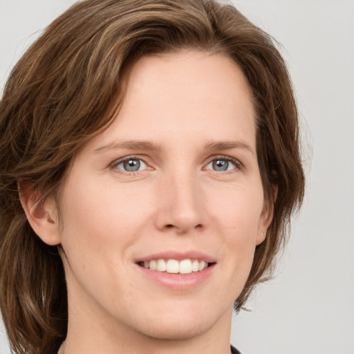 Joyful white young-adult female with medium  brown hair and green eyes