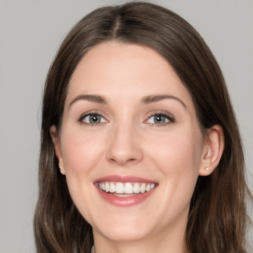 Joyful white young-adult female with long  brown hair and grey eyes