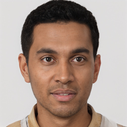 Joyful latino young-adult male with short  black hair and brown eyes