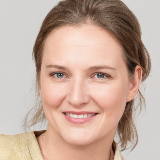 Joyful white young-adult female with medium  brown hair and grey eyes