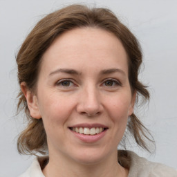 Joyful white young-adult female with medium  brown hair and grey eyes