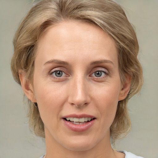 Joyful white adult female with medium  brown hair and grey eyes