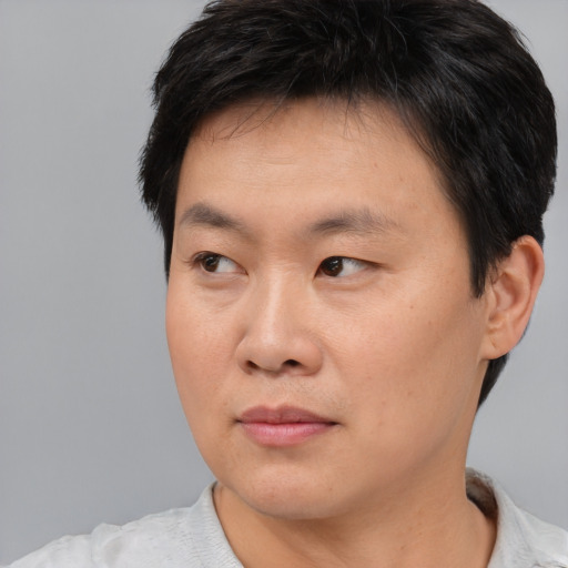 Neutral asian adult male with short  black hair and brown eyes