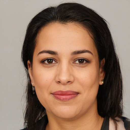 Joyful latino young-adult female with medium  brown hair and brown eyes