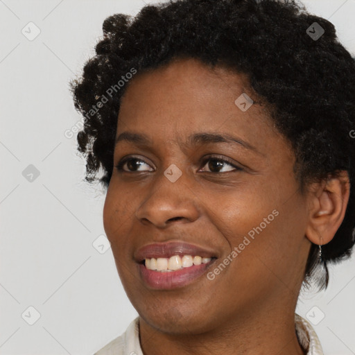 Joyful black young-adult female with short  black hair and brown eyes