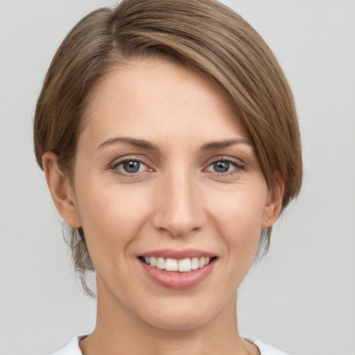 Joyful white young-adult female with medium  brown hair and grey eyes