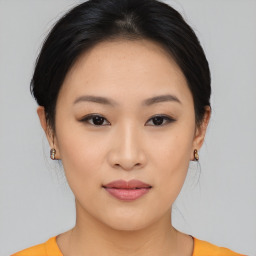 Joyful asian young-adult female with medium  brown hair and brown eyes