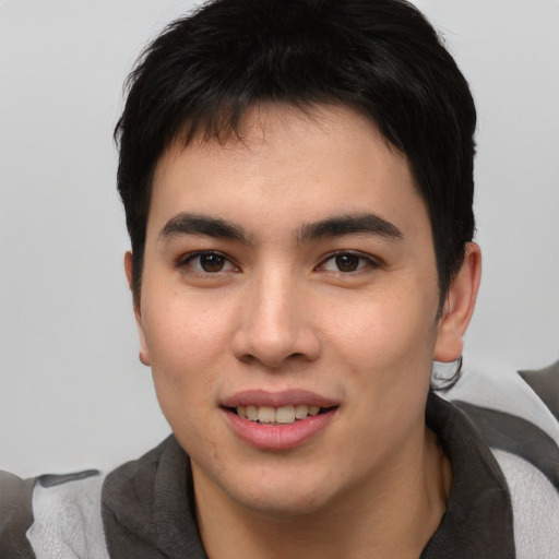 Joyful asian young-adult male with short  brown hair and brown eyes