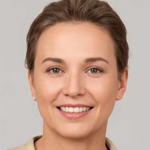 Joyful white young-adult female with short  brown hair and grey eyes