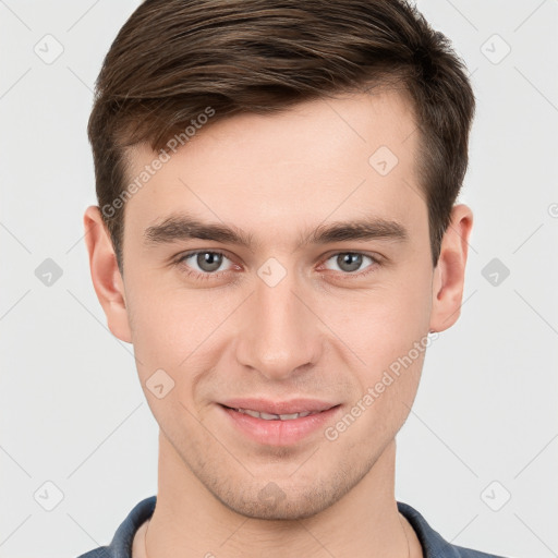 Joyful white young-adult male with short  brown hair and grey eyes