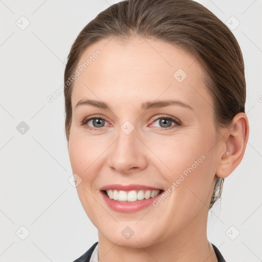 Joyful white young-adult female with medium  brown hair and grey eyes