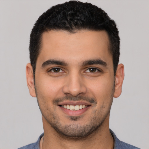 Joyful white young-adult male with short  black hair and brown eyes