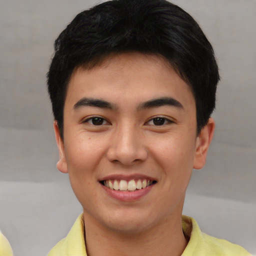 Joyful asian young-adult male with short  brown hair and brown eyes
