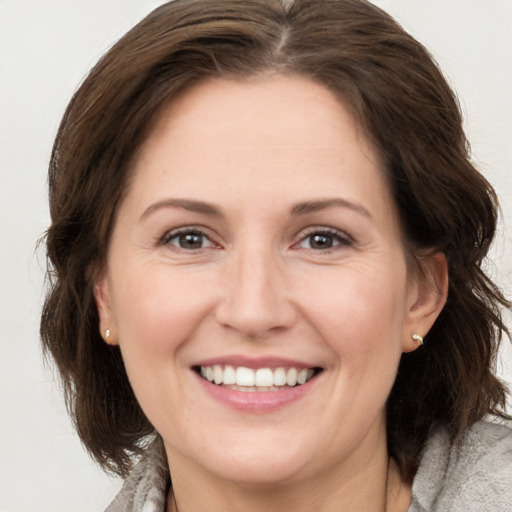 Joyful white adult female with medium  brown hair and brown eyes