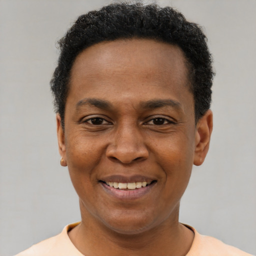 Joyful black adult male with short  black hair and brown eyes