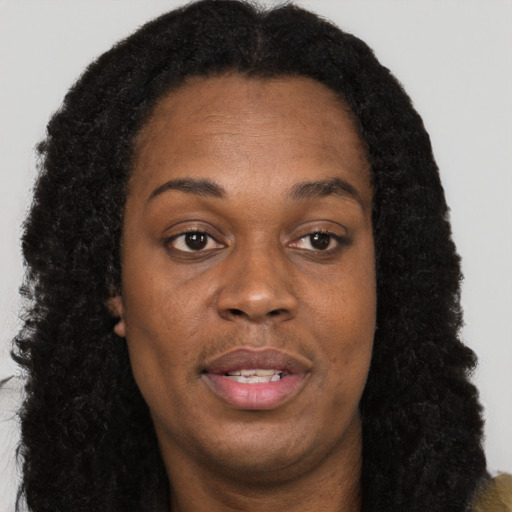 Joyful black adult female with long  brown hair and brown eyes