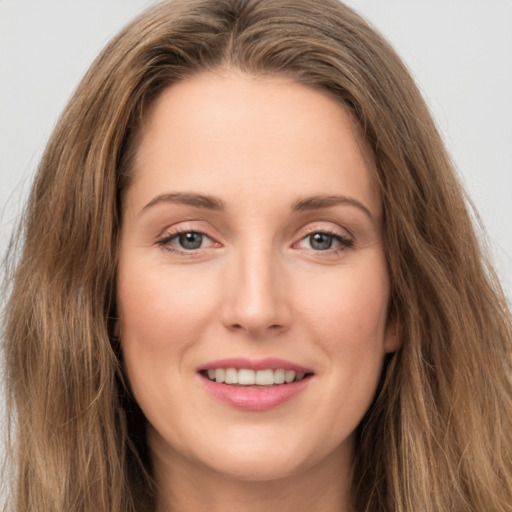 Joyful white young-adult female with long  brown hair and green eyes