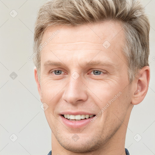 Joyful white adult male with short  brown hair and grey eyes