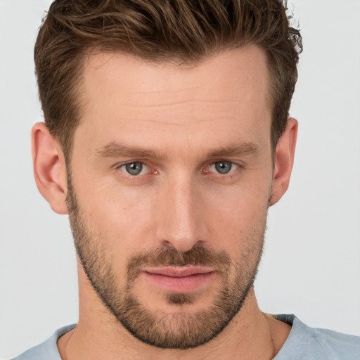 Joyful white young-adult male with short  brown hair and grey eyes