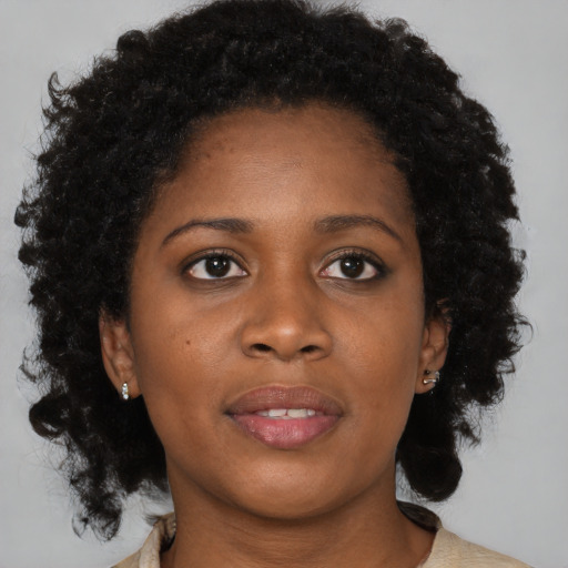 Joyful black young-adult female with medium  brown hair and brown eyes