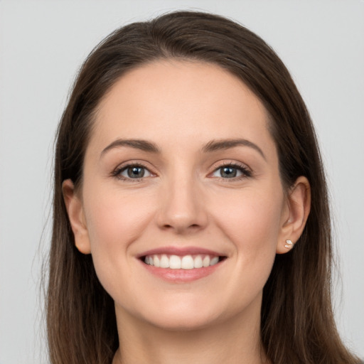 Joyful white young-adult female with long  brown hair and grey eyes