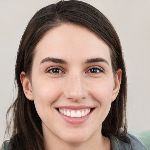 Joyful white young-adult female with long  brown hair and grey eyes