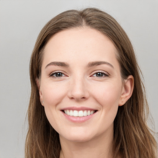 Joyful white young-adult female with long  brown hair and grey eyes