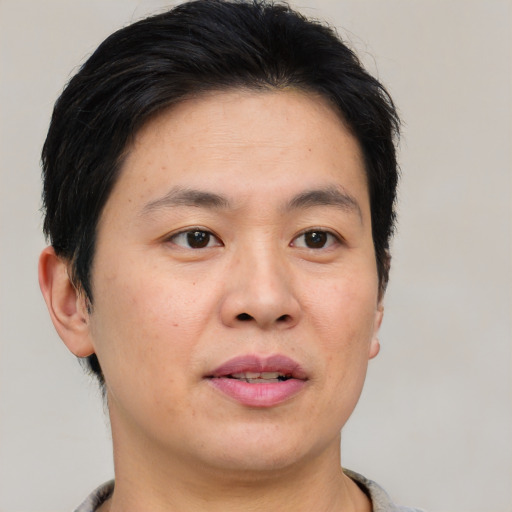 Joyful asian adult male with short  brown hair and brown eyes