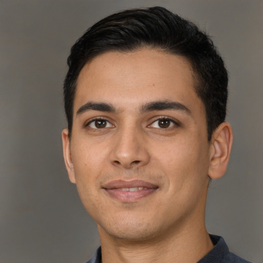 Joyful latino young-adult male with short  brown hair and brown eyes