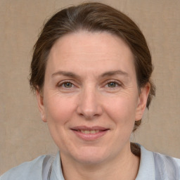 Joyful white adult female with medium  brown hair and grey eyes