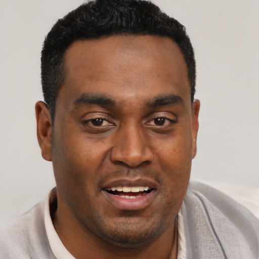 Joyful black young-adult male with short  black hair and brown eyes