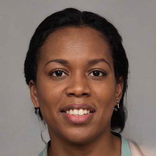 Joyful black young-adult female with long  black hair and brown eyes