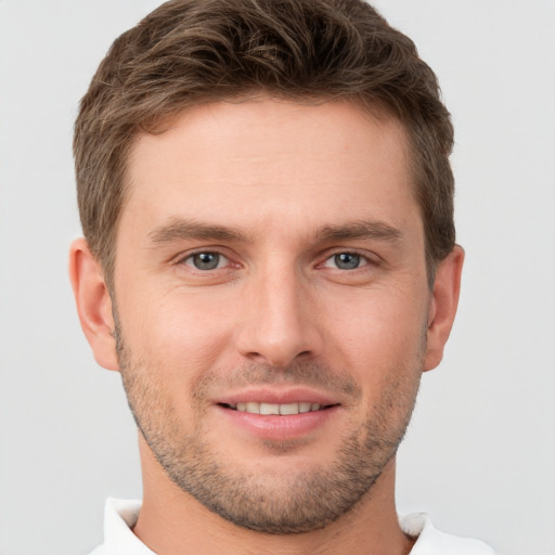 Joyful white young-adult male with short  brown hair and grey eyes