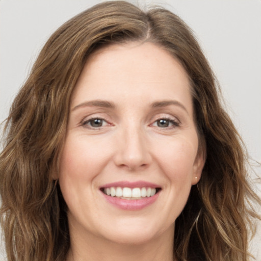 Joyful white young-adult female with long  brown hair and green eyes